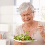 Mulher idosa comendo salada - envelhecimento