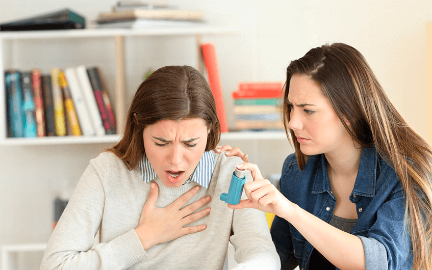 Mulher entregando bombinha para amiga com crise de asma