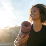 Mulher sorrindo com tapete de meditação - hormônios femininos