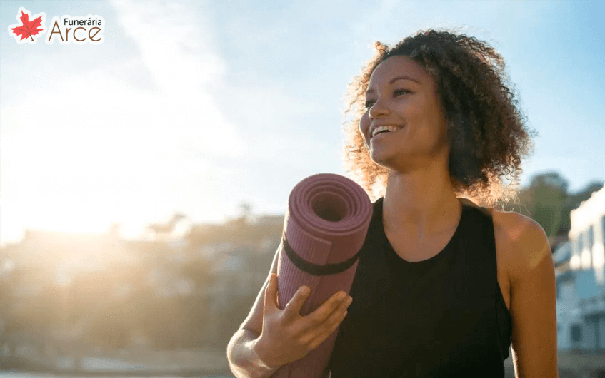 Mulher sorrindo com tapete de meditação - hormônios femininos